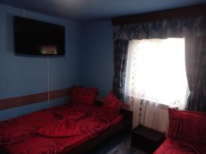 - une chambre avec un lit rouge et une fenêtre dans l'établissement Casa de vacanta, à Eforie Nord