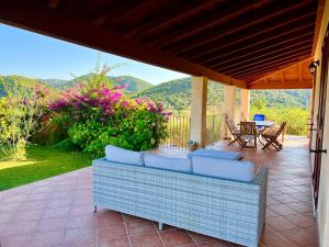un patio con sofá, mesa y sillas en Villa La Vigna, en Domus de Maria