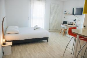 um quarto com uma cama e uma secretária com um computador em Twenty Business Flats Nîmes Trigone em Nîmes