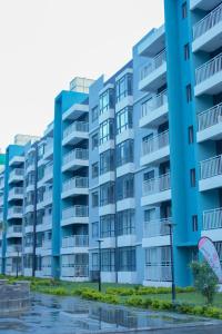 a blue apartment building with water in front of it at Indesign Makumbi park studio Apartment D4-5,Syokimau in Syokimau