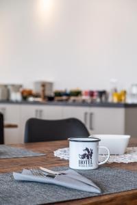 a coffee cup sitting on top of a wooden table at Hotel Fuchs & Hase SELF CHECK IN in Rosegg