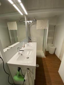 ein Badezimmer mit einem weißen Waschbecken und einem Spiegel in der Unterkunft O Cerrulo Apartamento céntrico Pontedeume in Puentedeume