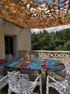 una mesa con mantel azul y sillas blancas en Mas de Gaussel en Cabrières