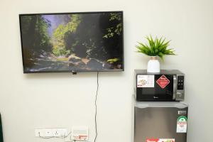 a tv hanging on a wall next to a refrigerator at Airport Studio Gym pool fast WIFI Ideal for digital nomads Syokimau in Syokimau