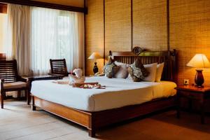 a bedroom with a bed with a teddy bear on it at Sri Phala Resort & Villa in Sanur