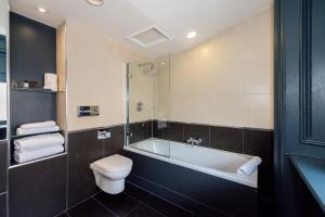 a bathroom with a tub and a toilet and a sink at 62 Castle Street Hotel in Liverpool +79 photos