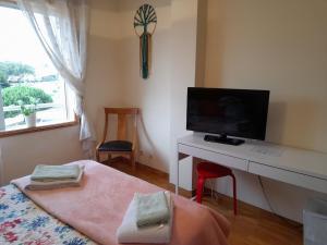 1 dormitorio con 1 cama y escritorio con TV en Aguda Mar - V N Gaia, en Aguda