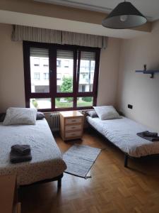 1 dormitorio con 2 camas y ventana grande en Amplio apartamento con todas las comodidades en Oviedo, en Oviedo