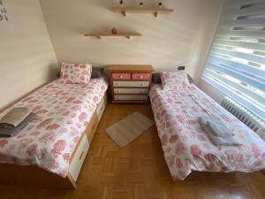 Amplio apartamento con todas las comodidades en Oviedo في أوفِييذو: غرفة نوم بسريرين وخزانة ونافذة