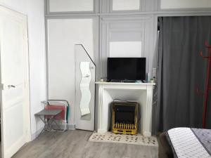 - une chambre avec un lit, une télévision et une cheminée dans l'établissement Avec un minimum de 3 nuits Studio 80 m de la mer et 300 m des commerces, au Tréport