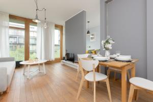 a dining room and living room with a table and chairs at Cozy & Sunny Studio for 4 Guests Kolejowa Warsaw by Renters in Warsaw