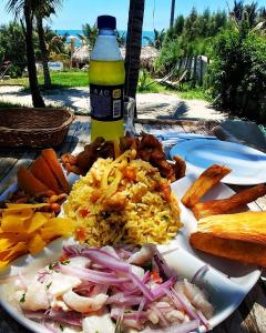 un plato de comida con arroz y una botella de cerveza en Marcilia Beach Bungalows, en Los Órganos