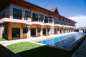 een hotel met een zwembad voor een gebouw bij Dream Residences in Manolo Fortich