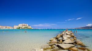 a group of people in the water at a beach at Joli 2 chambres sur Lumio, vue à couper le souffle. in Lumio