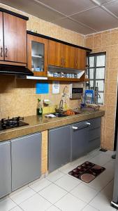una cocina con armarios de madera y electrodomésticos de acero inoxidable en THE MILKY WAY @ PINE RESORT, en Bukit Fraser