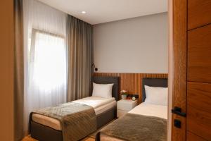 2 łóżka w małym pokoju z oknem w obiekcie Apart-hotel Dream w Maladze