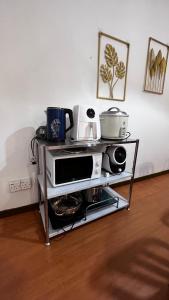 carrito de cocina con microondas, ollas y sartenes en THE MILKY WAY @ PINE RESORT, en Bukit Fraser