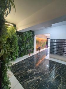 un hall d'entrée avec un mur végétalisé avec des plantes dans l'établissement Studio Isabela, à Năvodari