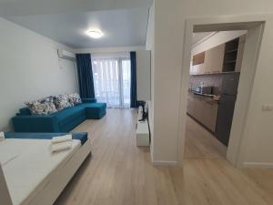un salon avec un canapé bleu et une cuisine dans l'établissement Studio Isabela, à Năvodari 7 autres photos