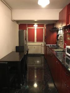 a kitchen with red walls and a black counter top at Majestic Luxury Apartment Close to Presidential Palace in Bucharest