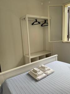 a bedroom with two towels on a bed with a mirror at Holiday Home Eurovillage in Torre Lapillo