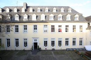 特里尔Kolping Hostel Trier im Warsberger Hof的一栋有很多窗户的白色大楼 更多14张照片