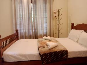 1 dormitorio con 2 camas con sábanas blancas en Sinai Homestay en Alleppey