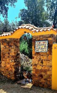 uma entrada para um edifício de pedra com uma placa em Quinta do Cabril em Serpins