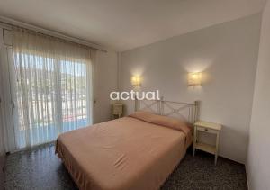 a bedroom with a bed and a large window at SANT JOSEP 3E in Platja  d'Aro