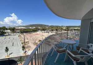 a balcony with a table and chairs and a beach at SANT JOSEP 3E in Platja  d'Aro