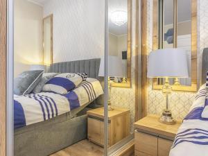 een slaapkamer met een bed en een spiegel bij Glow Apartments, Apartamenty przy Chmielnej Śródmieście in Gdańsk