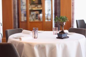 una mesa con un mantel blanco y una planta en ella en Poli Hotel, en San Vittore Olona