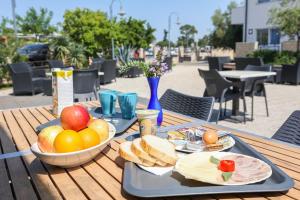 bandeja de fruta y pan en una mesa de madera en HI Hostel Zadar en Zadar