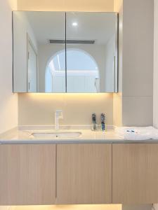 La salle de bains est pourvue d'un lavabo et d'un miroir. dans l'établissement Three Bedroom Apartment near Xintiandi, à Shanghai
