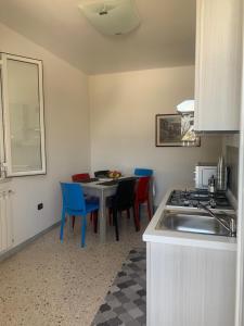 a kitchen with a table and chairs and a sink at Casa vacanza Ilaria in Torre Lapillo