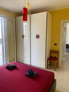 1 dormitorio con 1 cama con colcha roja en Casa vacanza Ilaria, en Torre Lapillo