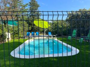 a pool with an umbrella in a fence at Partisole in Garéoult