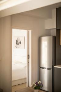 a kitchen with a refrigerator and a man in a bedroom at Sky-view Hideaway in Nicosia