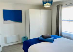 a bedroom with a bed and a large window at Oceano - Carbis bay, St Ives, 1 bed apartment with free parking near to the beach in St Ives