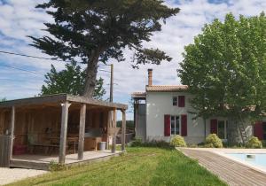 uma casa com um pavilhão ao lado de uma piscina em Ravissant studio à la ferme avec piscine em Jau-Dignac-et-Loirac