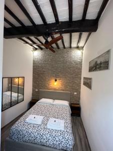 a bedroom with a bed and a brick wall at Residenza la Mandorla in Perugia +52 photos