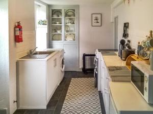 cocina con fregadero y lavavajillas en Beech Cottage, en Hepple