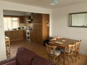 ein Wohnzimmer und eine Küche mit einem Tisch und Stühlen in der Unterkunft ONeills Apartments in Ballyheigue