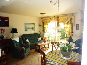 Una sala de estar con un sofá verde y una mesa. en Edison Bungalow Duplex LEK, en Peñíscola