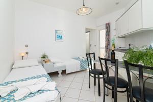 una camera con letto, tavolo e sedie di Sunshine Garden Apts a Mália