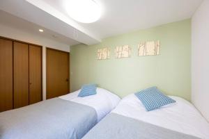 dwa łóżka siedzące obok siebie w sypialni w obiekcie Elle's Shirokane Guest house 301 w Tokio