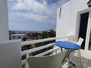 a balcony with a blue table and chairs at Galini Rooms Sikinos Travel in Sikinos