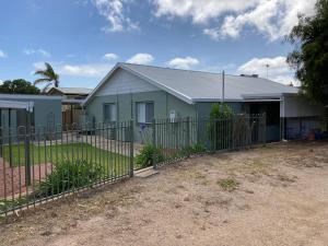 a house with a fence in front of it at Sea Salt at Stansbury Apartment 1 in Stansbury