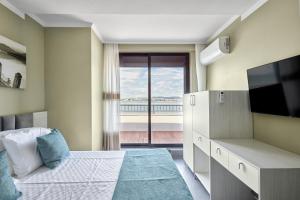 een slaapkamer met een bed, een tv en een raam bij 3BD Beach Paradise with a Stunning View + Parking in Nesebar