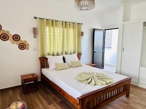a bedroom with a large bed with white sheets at Ofim Holidays in Ambohidratrimo